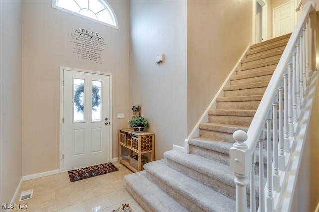 foyer entrance with a high ceiling and light tile patterned floors