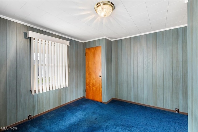 unfurnished room featuring ornamental molding and dark colored carpet