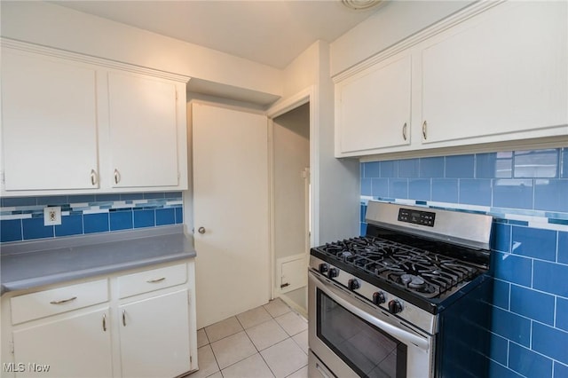 kitchen featuring white cabinetry, stainless steel range with gas cooktop, decorative backsplash, and light tile patterned floors