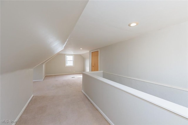 interior space featuring vaulted ceiling and light colored carpet