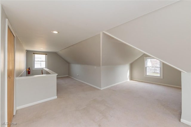 bonus room featuring light colored carpet and vaulted ceiling