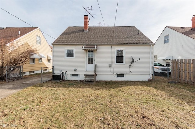 rear view of property featuring central AC and a yard