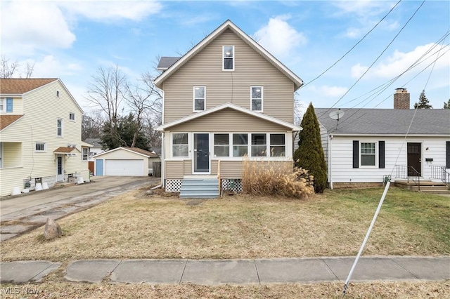 front of property with an outbuilding, a garage, a front yard, and a sunroom