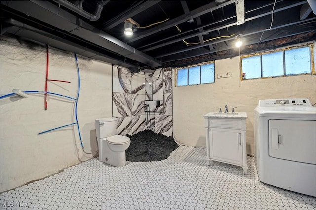 washroom with cabinets, washer / dryer, and sink