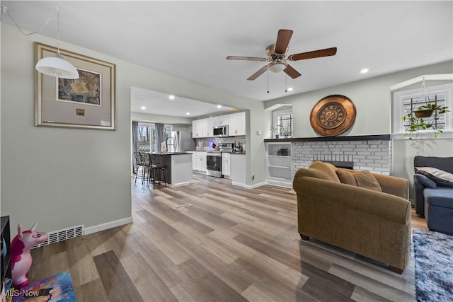 living room with ceiling fan and wood-type flooring