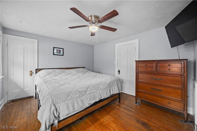 bedroom featuring dark wood-type flooring, a closet, and ceiling fan