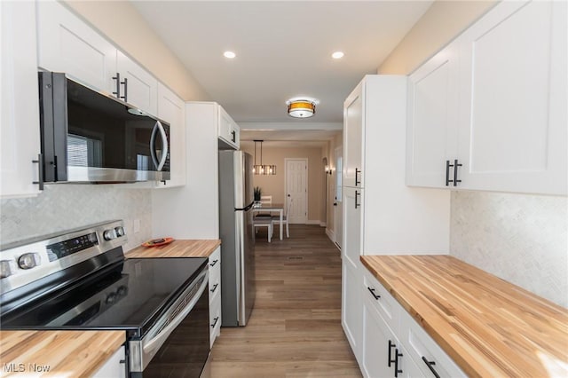 kitchen with white cabinetry, appliances with stainless steel finishes, butcher block counters, and light wood-type flooring