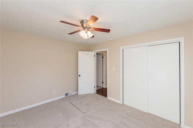 unfurnished bedroom featuring light colored carpet, ceiling fan, and a closet