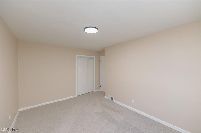 unfurnished room featuring light colored carpet