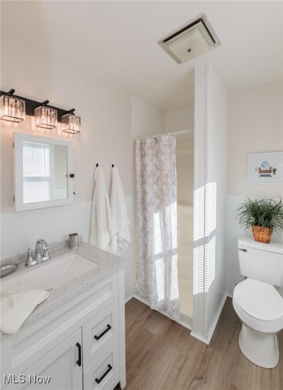 bathroom with vanity, toilet, hardwood / wood-style floors, and a wealth of natural light