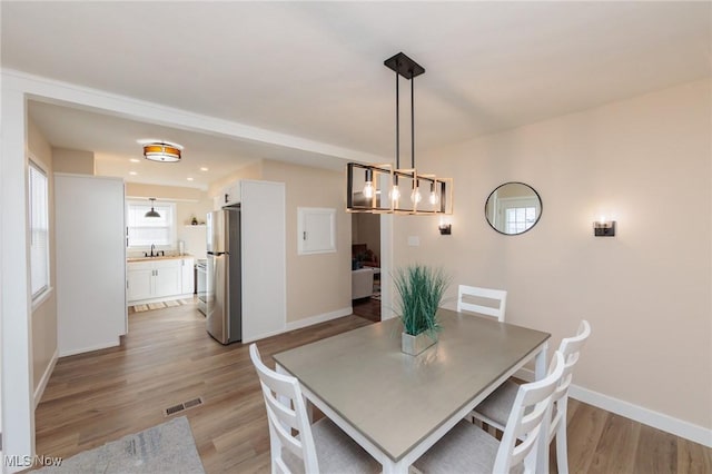 dining space featuring sink and light hardwood / wood-style floors