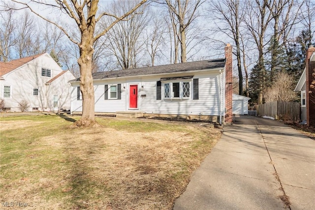 view of front facade with a garage, an outbuilding, and a front lawn