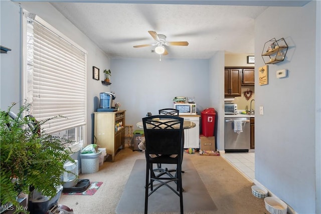 interior space featuring ceiling fan, appliances with stainless steel finishes, light carpet, and a textured ceiling