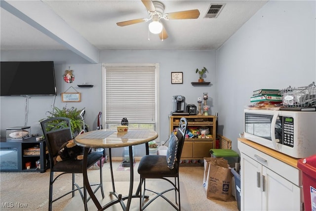 dining room featuring light carpet and ceiling fan