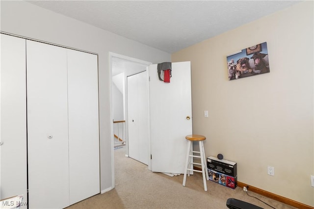 carpeted bedroom featuring a closet and a textured ceiling