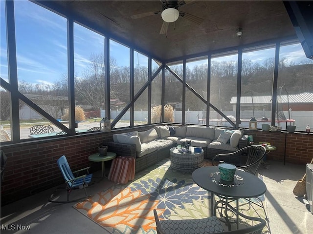 sunroom / solarium featuring ceiling fan