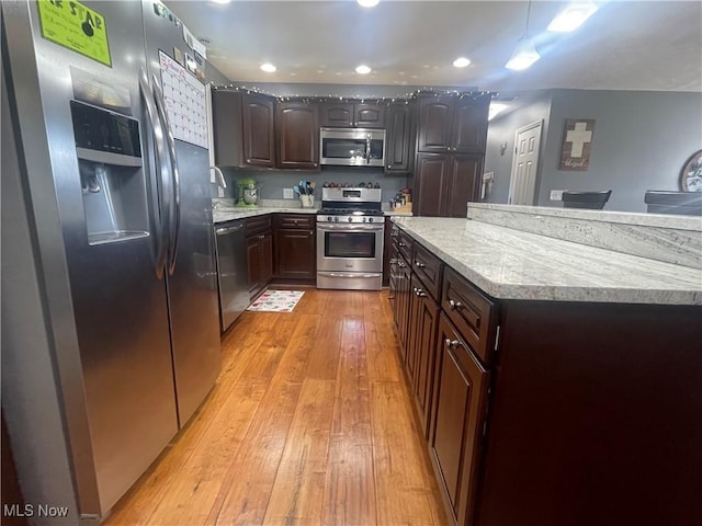 kitchen featuring dark brown cabinetry, stainless steel appliances, sink, and light hardwood / wood-style floors