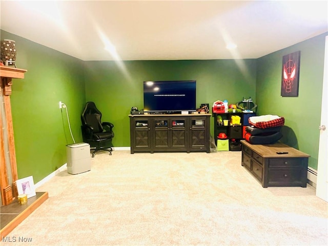 game room featuring a baseboard heating unit and light colored carpet