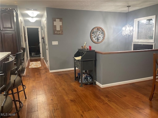 hall with hardwood / wood-style flooring and a chandelier