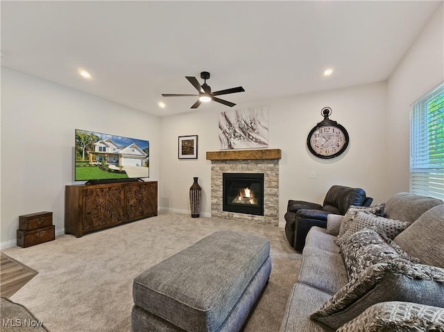 living room featuring ceiling fan, carpet, and a fireplace