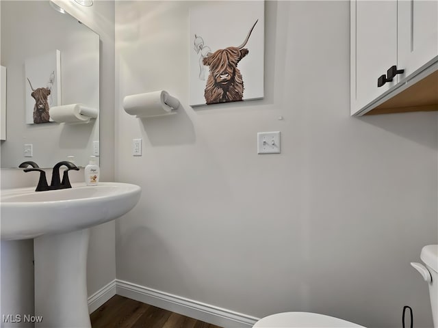 bathroom with toilet and hardwood / wood-style floors