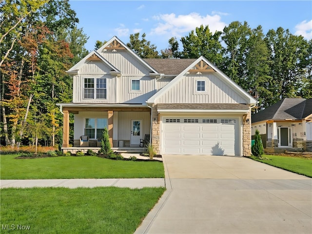 craftsman house with a garage, covered porch, and a front yard