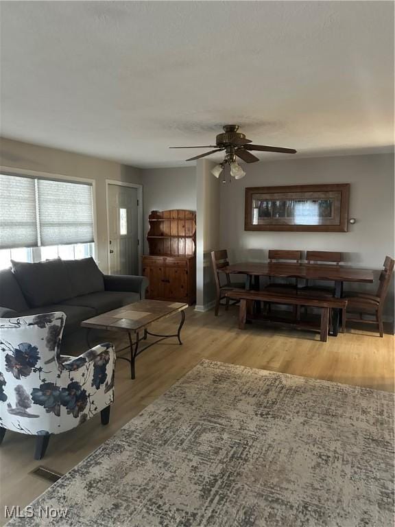 living room with ceiling fan and light wood-type flooring