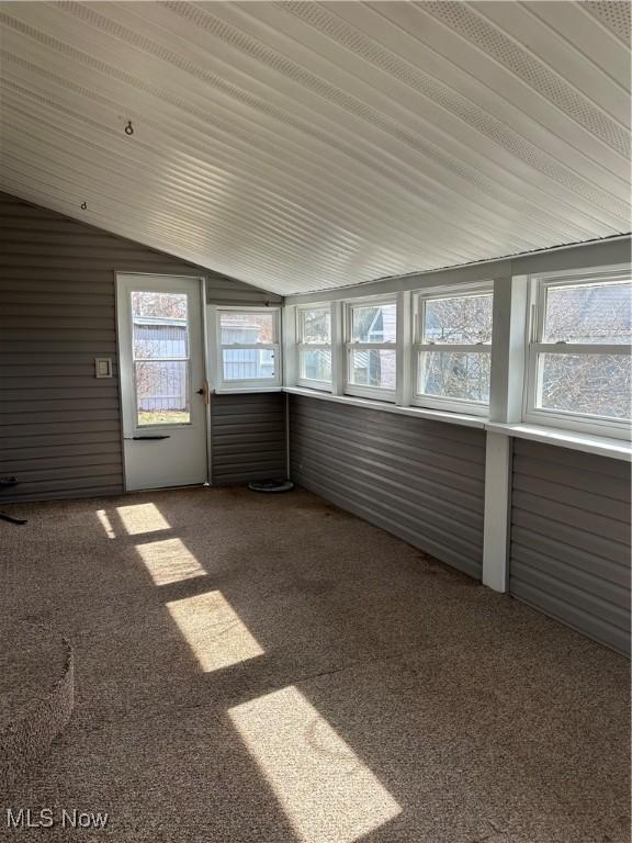 unfurnished sunroom featuring vaulted ceiling and a wealth of natural light