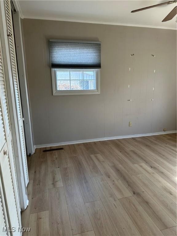 unfurnished bedroom with ornamental molding, ceiling fan, and light wood-type flooring