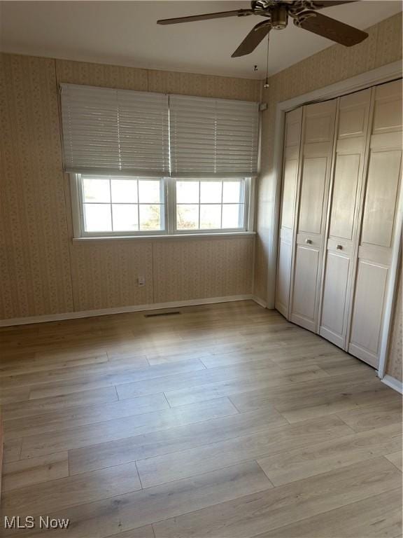 unfurnished bedroom featuring a closet, ceiling fan, and light hardwood / wood-style flooring