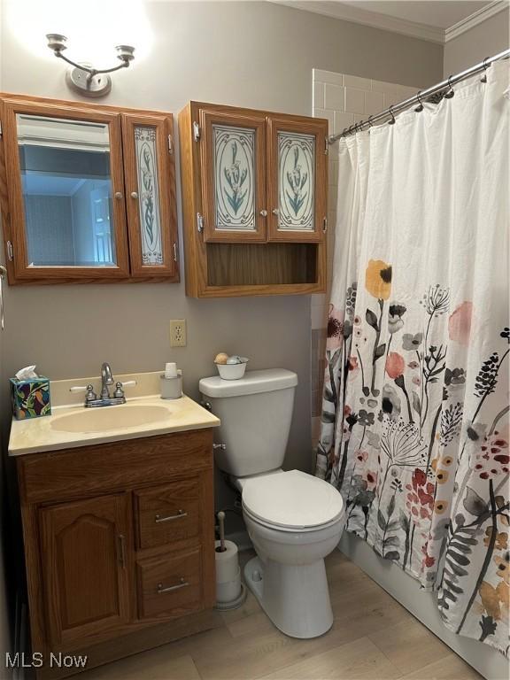 bathroom with a shower with curtain, crown molding, vanity, and toilet