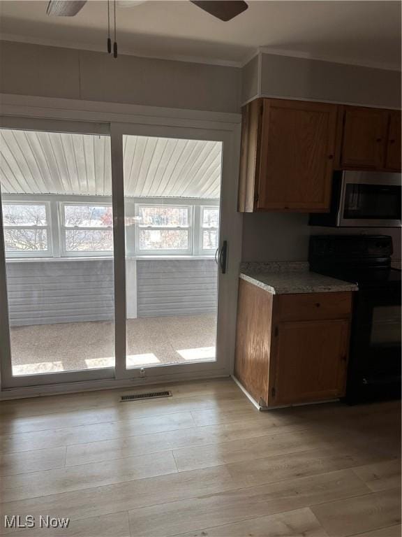 kitchen featuring black range with electric stovetop, crown molding, light hardwood / wood-style flooring, and ceiling fan