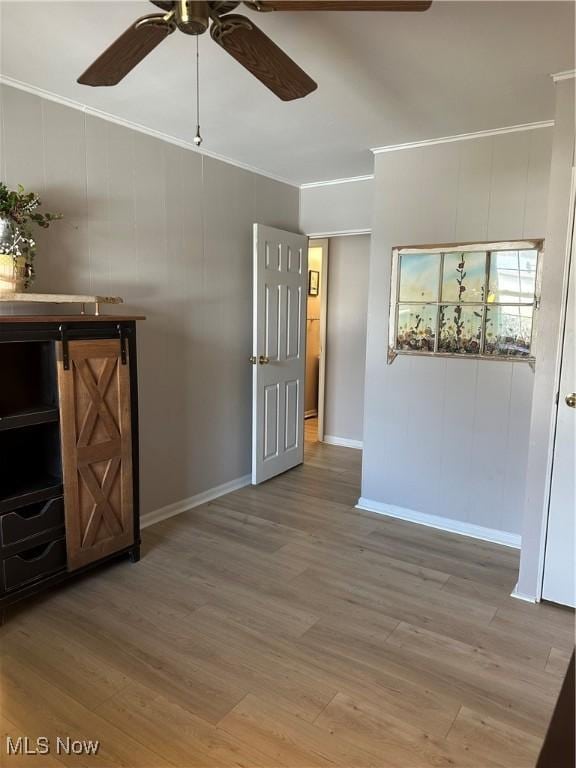 spare room with crown molding, ceiling fan, and light hardwood / wood-style flooring