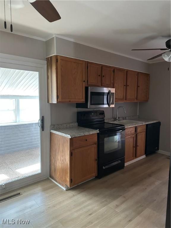 kitchen with sink, light hardwood / wood-style flooring, ornamental molding, ceiling fan, and black appliances