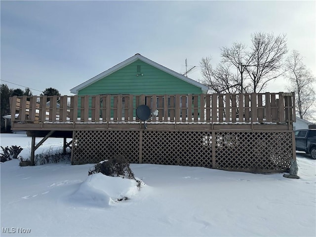 snow covered house with a deck