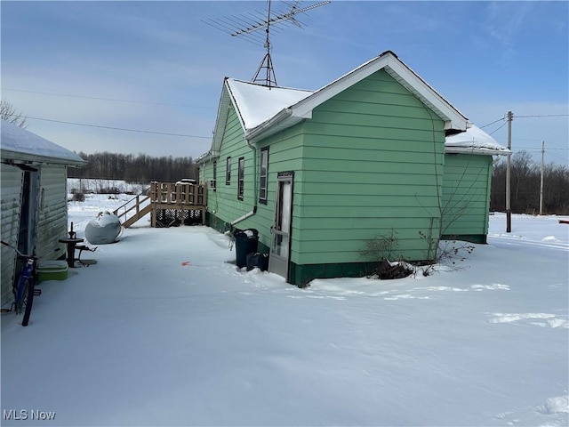 snow covered property featuring a wooden deck