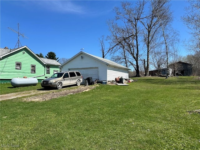 view of side of property with a garage, an outbuilding, and a yard