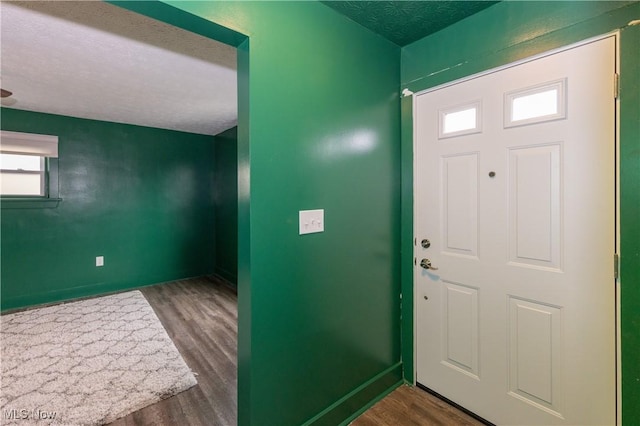 entryway featuring dark wood-type flooring and a textured ceiling