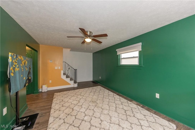 unfurnished room featuring wood-type flooring, a textured ceiling, and ceiling fan