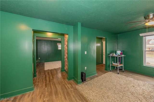 empty room featuring ceiling fan, hardwood / wood-style floors, and a textured ceiling