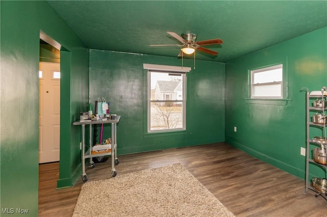 interior space with ceiling fan, wood-type flooring, and a textured ceiling