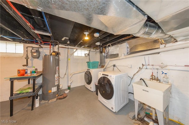 basement featuring water heater, washer and dryer, and sink