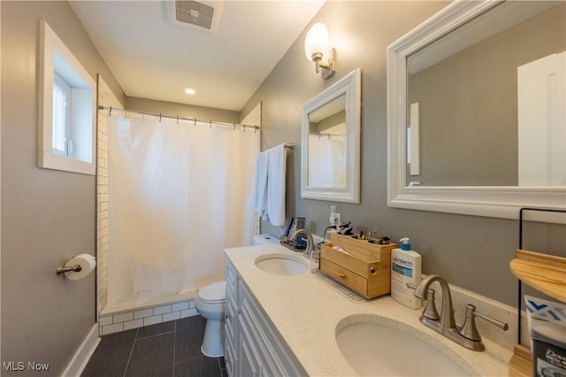 bathroom with vanity, curtained shower, and toilet