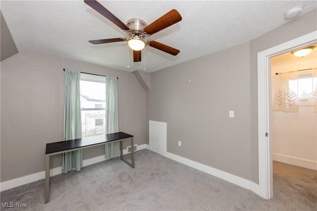 bonus room with a wealth of natural light, light colored carpet, a textured ceiling, and vaulted ceiling