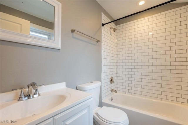 full bathroom with vanity, tiled shower / bath combo, and toilet