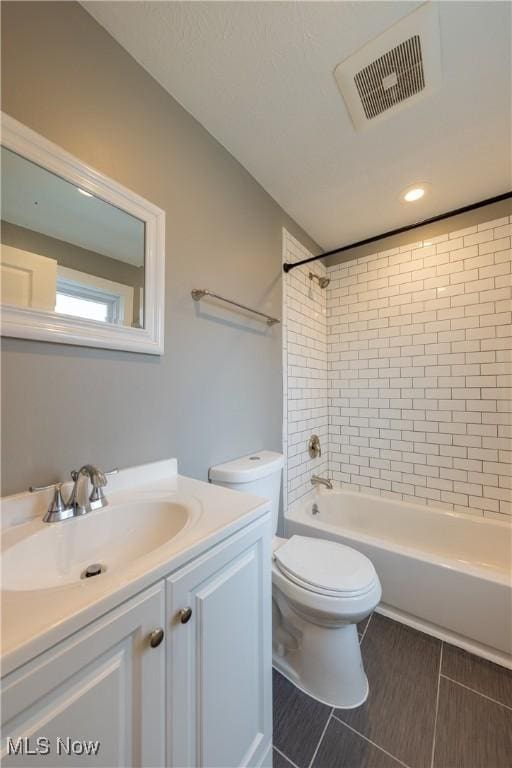 full bathroom featuring tiled shower / bath combo, vanity, and toilet