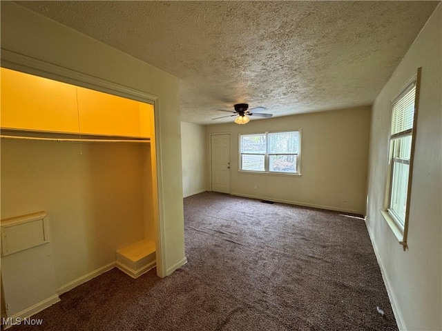 unfurnished bedroom with ceiling fan, a closet, a textured ceiling, and carpet