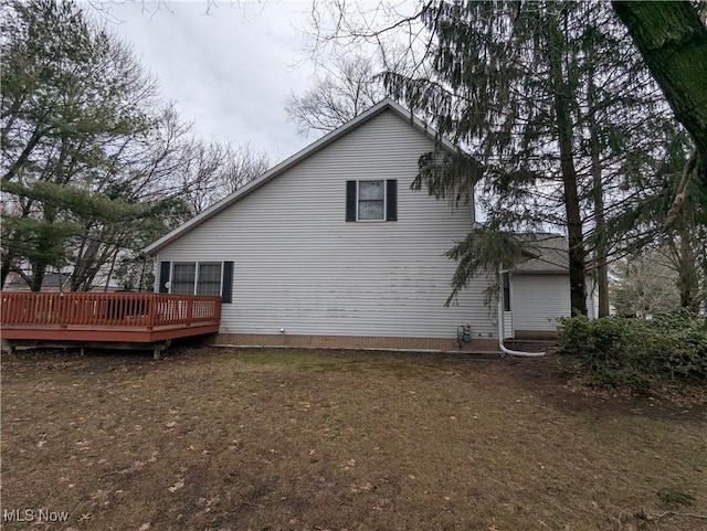 view of home's exterior featuring a wooden deck and a yard