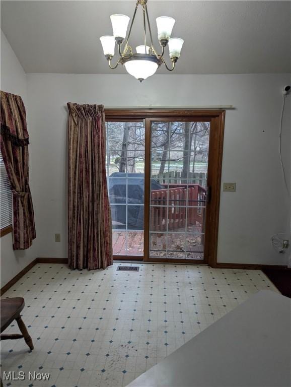 unfurnished dining area featuring a notable chandelier