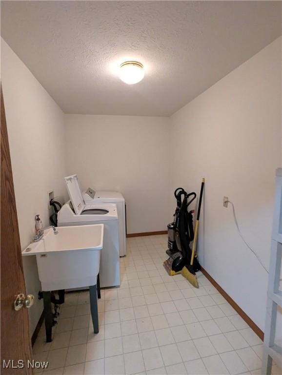 washroom with separate washer and dryer, sink, and a textured ceiling